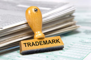 Trademark stamp for Weiss and Moy IP Law leaning against paperwork on a desk